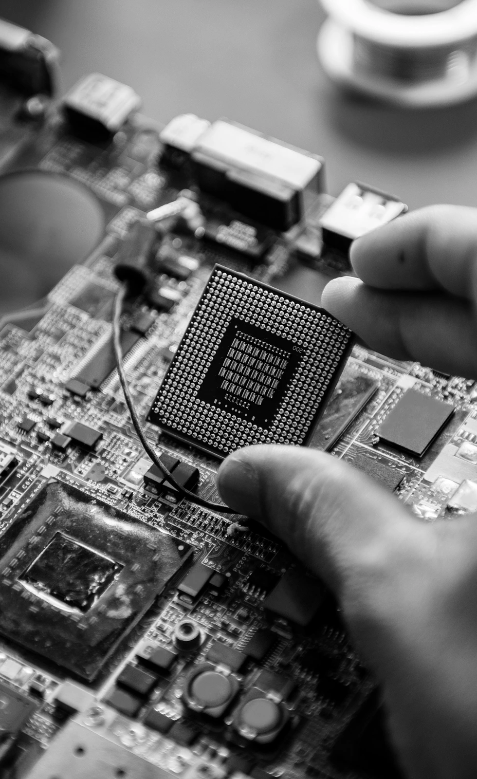 Engineer holding a BGA processor above a motherboard