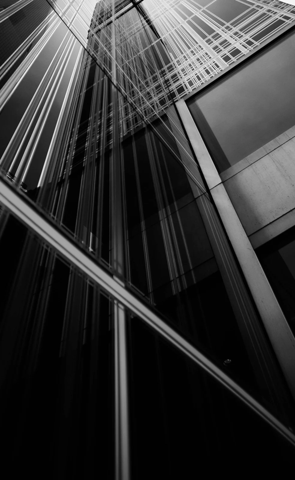 Glass tower receding upward against a dark sky